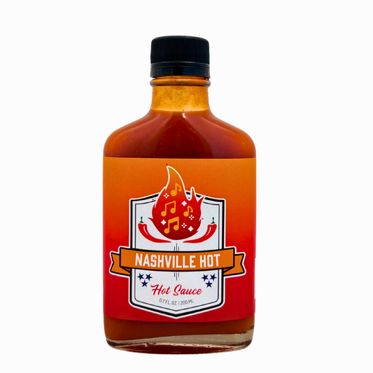 Bottle of Nashville Hot hot sauce with a red label on a white background